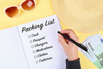 Packing list for summer vacation on sheet of notebook. Vacation travel concept.