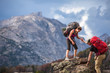 © Tandem Stock - Woman helping man while climbing on rock