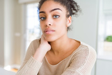 Beautiful Young African American Woman With Blue Eyes Relaxing At Home, With Confident Expression On Face