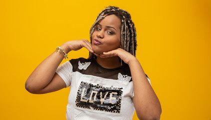 Wall Mural - Beautiful young african american woman with dread hair on yellow background