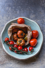 Sardinian Beef Tomatoes In Paper Bag, Ripe Of Mini Plum Tomatoes And Roma Tomatoes On Plate