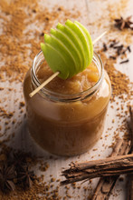 Decorated With Green Apple Appetizing Juicy Applesauce In Glass Jar And Cinnamon On Wooden Background