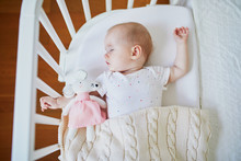 Baby Sleeping In Co-sleeper Crib Attached To Parents' Bed