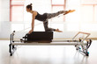 Pilates reformer workout exercises woman at gym indoor