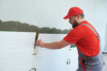 Tiler installing large size tile on wall. home indoors renovation