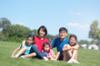 © Kenishirotie - Happy Asian family with children outdoors in park during summer