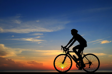 Wall Mural - Silhouette  cycling  on blurry sunrise  sky   background.