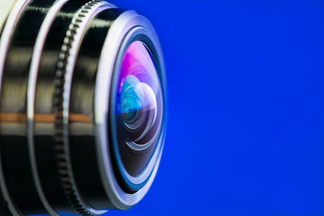 Wall Mural - Camera lens with blue backlight. Side view of the lens of camera on blue background. Blue camera Lens close Up.