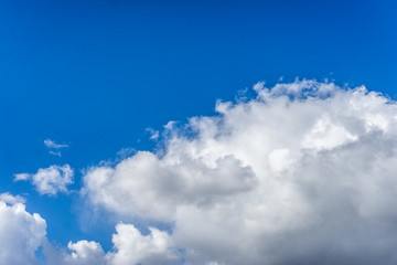 Wall Mural - Fluffy white clouds against a bright, colorful blue sky