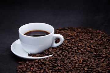 cup of coffee with beans on wooden background