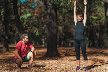 Wall Mural - Friends stretching after training in the park