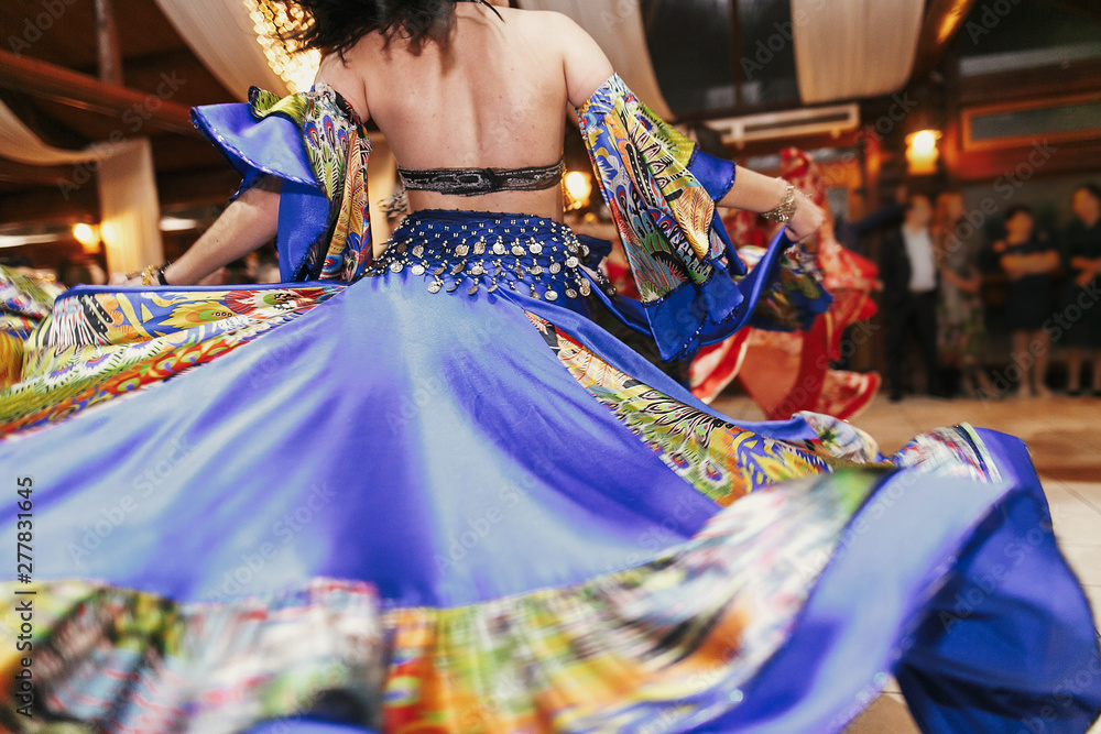 Beautiful gypsy girls dancing in traditional blue floral dress at wedding  reception in restaurant. Woman performing romany dance and folk songs in  national clothing. Roma gypsy festival Stock-foto | Adobe Stock