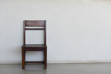 Old wooden chair on the old wall background