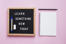 Stationeries With Learn Something New Today Text On Slate Over Pink Backdrop