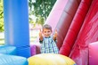 © Gorodetskaya - having fun on the slide in the fun park in bouncy castle climbing stairs