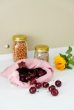 Fototapeta Tulipany - Heap of Fresh Ripe Cherry in Bag on White Table