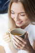 © Adamov - Renew your mind every morning. Close up of cheerful blonde girl drinking coffee in the morning