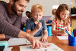 © Monkey Business - Elementary School Teacher Helping Pupils As They Work At Desk In Classroom