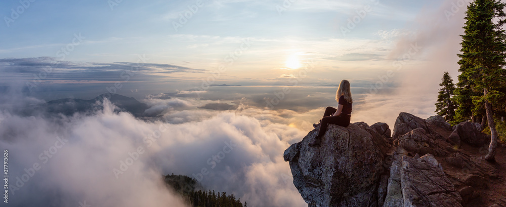 Adventurous Female Hiker on top of a mountain covered in clouds during a vibrant summer sunset. Taken on top of St Mark's Summit, West Vancouver, British Columbia, Canada. - obrazy, fototapety, plakaty 