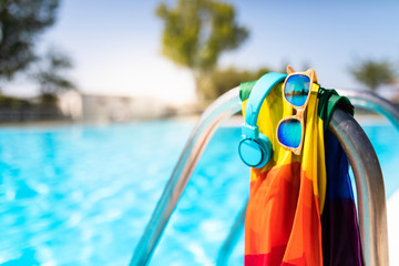 summer pool with blue water and rainbow colored flag