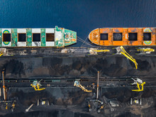 Cranes Loading Coal Anthracite On Bulk Vessel Ship In Offshore Cargo Port. Aerial Top View