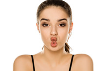 Portrait Of Beautiful Young Woman Making Fish Face On White Background