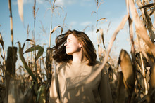 Young Woman With Eyes Closed Standing In Corn Field