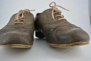 Women's unusual gray brown shoes, shoes from genuine leather in the English style. Aristocratic and antique shoes with worn leather and special colors are located on a white background.