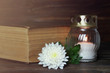White memorial candle, chrysanthemum flower and book