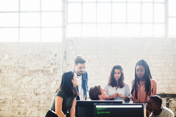 Professional programmers working in team while coding at creative workplace