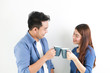 © chayathon2000 - Asian couple in blue shirt on white background with cup of coffee happy and smile mood