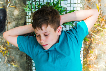 teen boy sleeping outdoors in summer