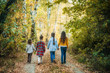 © Kiryakova Anna - A group of four children in the autumn forest. Children go on the road to the forest. View from the back