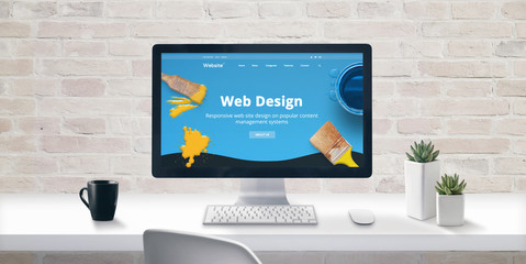 Leinwandbilder - Creative web design studio concept with web presentation on modern computer display. Cup of coffee and plants beside. Brick wall in background.
