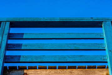 The span of the wooden railing of the pier against the sky