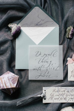 Flat Lay Wedding Invitation, Calligraphy And Close-up Cards With Ribbons, Marble Stones On Grey Textile Background