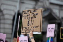 A Person Holding A Transgender Hate Crime Statistic Banner At A Gay Pride Event