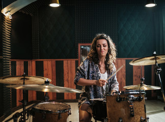 Wall Mural - Woman playing drums during music band rehearsal