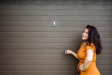 Garage door PVC. Girl or young woman holds remote controller for closing and opening garage door