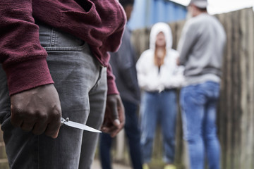 Close Up Of  Teenage Boy In Urban Gang Holding Knife