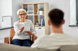© Syda Productions - psychology, mental therapy and people concept - senior woman psychologist with clipboard and young man patient at psychotherapy session