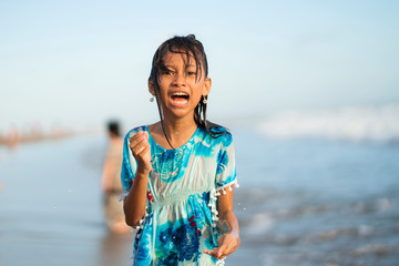 Wall Mural - beach lifestyle portrait of young beautiful and happy 7 or 8 years old Asian American mixed child girl with wet hair enjoying holidays playing in the sea having fun