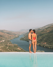 Man And Woman Kissing On The Edge Of Infinity Pool During Daytime