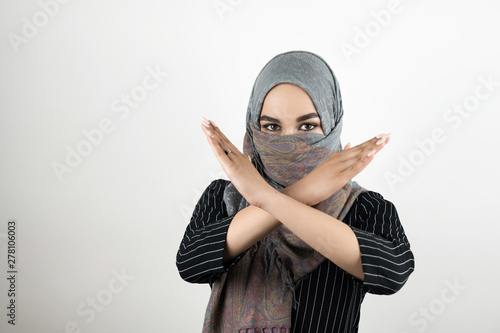 Fotomural young attractive Muslim student wearing turban hijab headscarf saying no to war