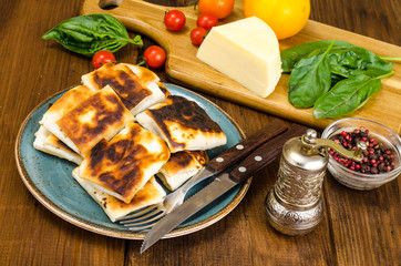 Wall Mural - Fried pita bread filled with cheese, tomato and greens