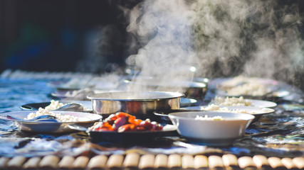 Hot food on bamboo table with smoke for breakfast