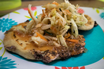 Papusas on a Plate Topped with Cabbage 