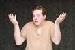 © Вячеслав Чичаев - Portrait to the waist on a gray background of a handsome young man in a brown T-shirt. stands directly in front of the camera in various poses, talking, demonstrating emotions.