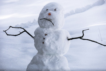 Sad snowman frowning in Sierra winter snow - California