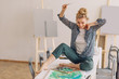 © alfa27 - cheerful young fair-haired girl rejoicing at her picture. artist celebrating her finished project. happiness concept. copy space